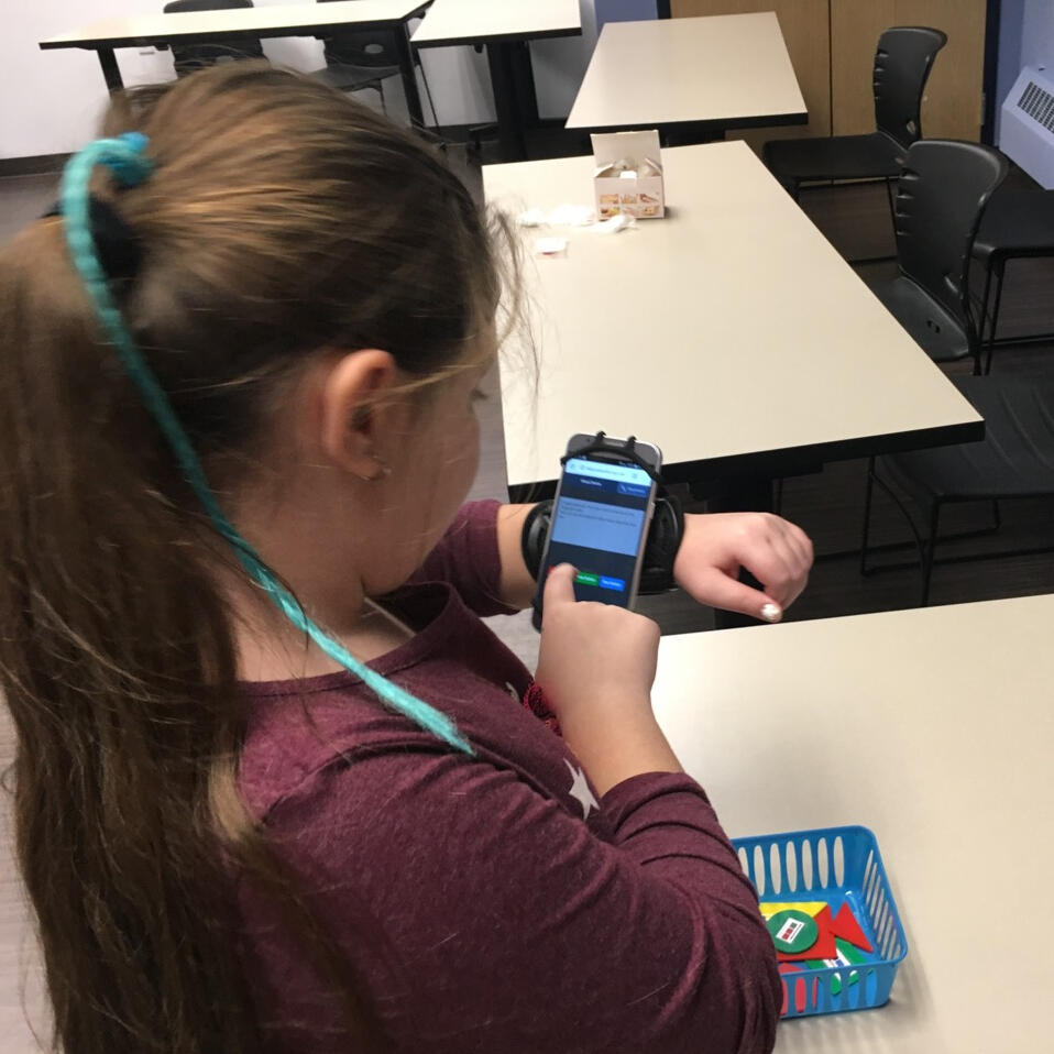 girl playing a WLCP game on her phone